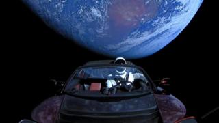 Dalam foto selebaran yang dibagikan oleh SpaceX, sebuah penjelajah Tesla diluncurkan dari sebuah roket dengan seorang pengemudi boneka bernama Starman menuju Mars