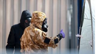   Emergency workers in protective gear search around a potentially contaminated site 