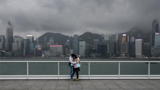A couple stand on the observation desk at Tsim Sha Tsui in Hong Kong on February 14, 2020