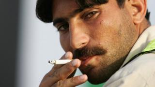 Пакистанский рабочий-строитель строит сигарету в Дубае