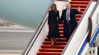 Donald Trump and first lady Melania walk down the stairs on Air Force One