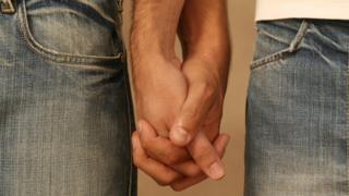 Two men holding hands