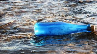 Una botella azul flotando en el agua