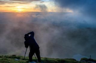Photographer in cloudy landscape