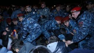 polis Yerevanda küçənin ortasında oturub yolu bağlayan nümayişçiləri kənara çıxardır