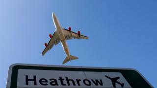 Plane flying over Heathrow sign
