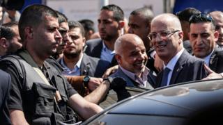 Palestinian Prime Minister Rami Hamdallah (2nd R) is greeted by Hamas security chief Tawfiq Abu Naim (C) upon his arrival in Gaza City on 13 March 2018