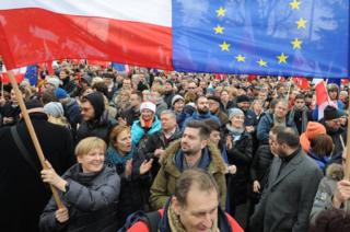 Протестующие развевают флаги Польши и Европейского Союза во время антиправительственной демонстрации в Варшаве, Польша, 19 декабря 2015 г.