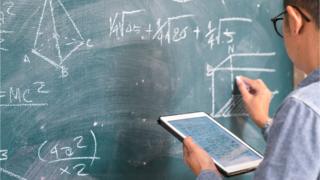 Professor em lousa de matemática