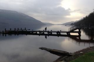 People at the edge of a loch