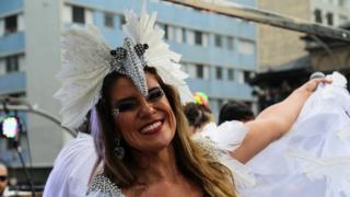 A festival-goer dances in a carnival outfit