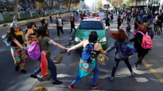 Demonstrators surround a police vehicle during a march demanding an end to sexism and gender violence in Santiago, Chile June 6, 2018
