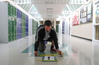 Social distancing tape is placed on a one way sign in a corridor, as preparations are made for the new school term at Alderwood School in Aldershot, Hampshire 26 August 2020