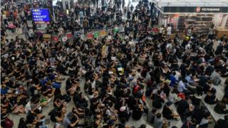 Hong Kong pro-democracy protesters (bottom) block access to the departure gates