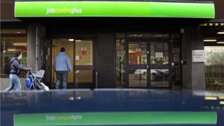 woman with pushchair and man walking into a job centre