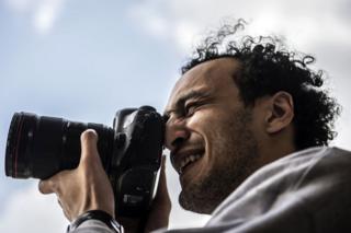 Egyptian photojournalist Mahmoud Abu Zeid, widely known as Shawkan, carries a camera at his home in the capital, Cairo, on 4 March 2019.