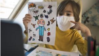 Маленький мальчик в маске с рисунками вируса