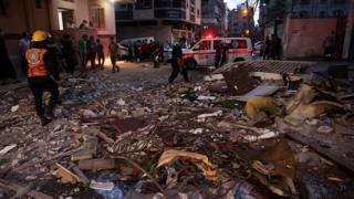 Palestinians check the rubble of an apartment destroyed by Israeli air strikes in Gaza on 11 May