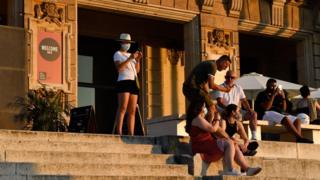 People sit on stairs in Barcelona