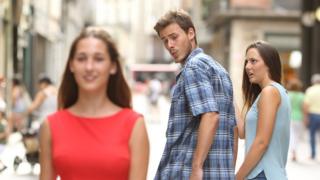Знаменитый интернет-мем о "отвлеченном парне" показывает мужчину, идущего по улице, держащего за руку свою подругу - но он оглядывается через плечо на молодую женщину в красном платье - но его подруга замечает, к ее шоку и смятению виден ее лицо.