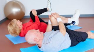 Man and woman exercising on a gym mat