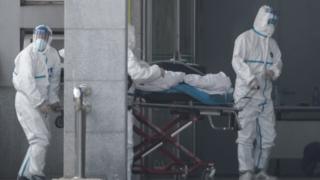 Medical staff carry a patient into the Jinyintan hospital in Wuhan on 18 January 2020.