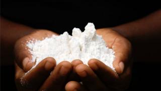 Close-up of an African woman's hands holding maize flour