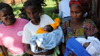 Women wey just born, hold pikin for hand