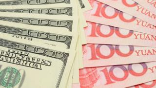 Доллары США и китайские банкноты юаня