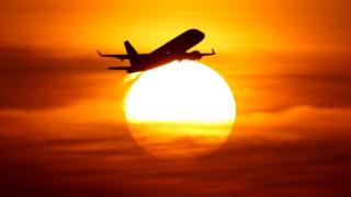 Avión vuela sobre el sol.