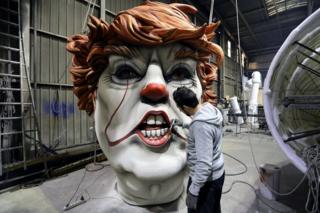 A man paints a giant model of a head