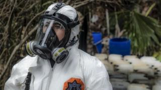 A Sinaloa state police officer works during the dismantle of one of the three clandestine laboratories producers of synthetic drug, mainly methamphetamine in El Dorado, Sinaloa state, Mexico on June 4, 2019.