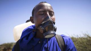 Man with face mask and spray canister in Ethiopia
