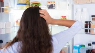 Mujer mirando comida con la cabeza tomada
