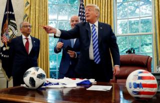 US President Donald Trump pretends to throw a red card at the news media