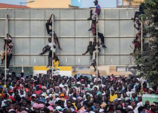 People clinging on to a billboard during a rally for presidential candidate Idrissa Djalo in Bissau, Guinea-Bissau - Tuesday 19 November 2019