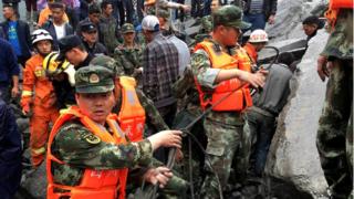 Rescue teams search for more than 100 people at the site of a landslide that reportedly destroyed some 40 homes in Xinmo Village, China, 24 June 2017
