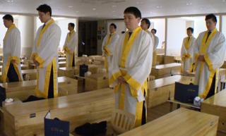 Employees standing next to coffins