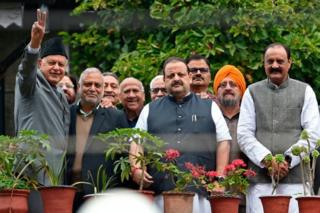 Former Jammu and Kashmir chief minister and leader of regional National Conference (NC) Farooq Abdullah (L) along with party colleagues gestures at his residence in Srinagar on October 6, 2019.