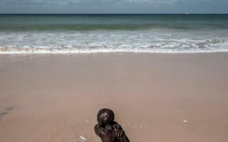 A Senegalese man cleans himself along the coastline in Bargny on August 15, 2020.