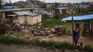 Девочка стоит возле своего дома в районе, где нет электросети или водопровода, примерно через две недели после того, как ураган «Мария» пронесся по острову 5 октября 2017 года в Сан-Исидро, Пуэрто-Рико.