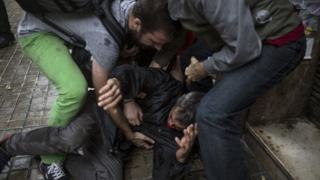 People help a man injured by a rubber bullet fired by Spanish police officers outside the Ramon Llull polling station in Barcelona October 1, 2017 during a referendum on independence for Catalonia banned by Madrid.