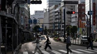 People cross a road in Japan where the nationwide state of emergency has been lifted for 39 of the country's 47 prefectures.