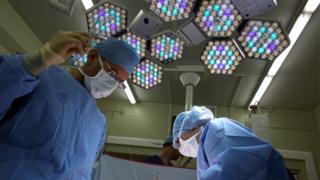 A surgeon and his theatre team performing surgery
