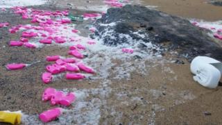 Hundreds of pink detergent bottles washed up on a beach