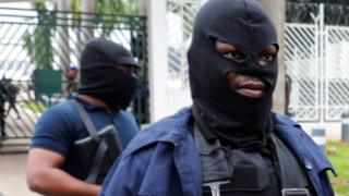 Masked men outside parliament in Nigeria
