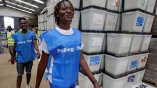 Election workers walk past ballot boxes and voting materials at the National Electoral Commission headquarters in Monrovia, Liberia October 9, 2017