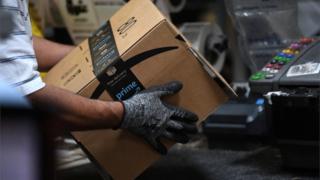 Worker assembles a box for delivery at the Amazon fulfilment centre.