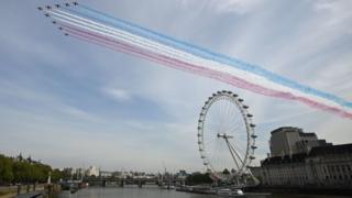 The Royal Air Force Red Arrows pass over the London Eye on the bank of the River Thames during a flypast in central London on 08 May 2020