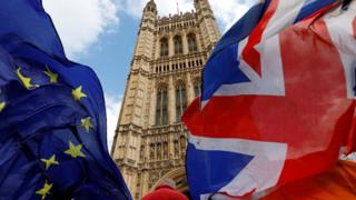 英国议会塔楼前飘扬着欧盟与英国的旗帜